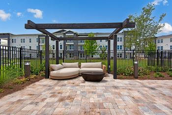 a patio with a couch and a table in front of a building at The Enclave at Deer Moss Creek, Niceville, FL, 32578